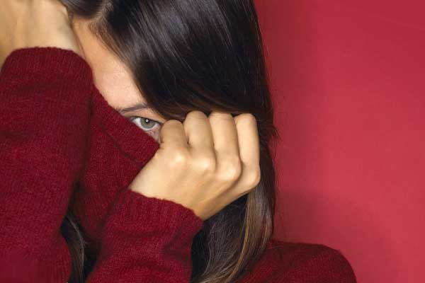 Девушка одевает бордовый свитер