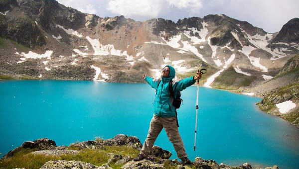 Турист на горе, голубое озеро