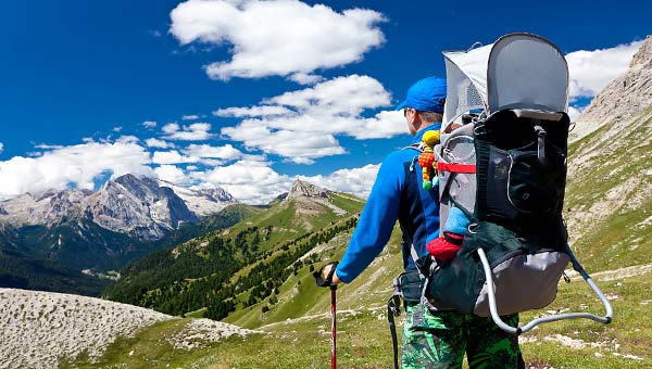 Турист с рюкзаком за плечами идет по горам