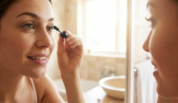 Девушка красит ресницы